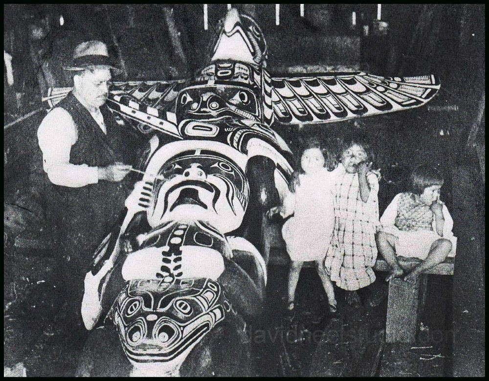 Charlie James carving a totem pole at Alert Bay, BC while his granddaughters (a young Ellen Neel on the right) watch & learn